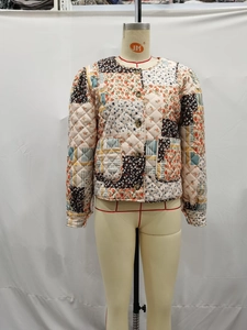 Detail of vintage patchwork quilted jacket with floral patterns and round neck design