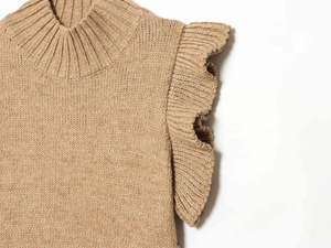 Detailed view of the camel knit top showing ruffled shoulders and high-neck ribbing texture