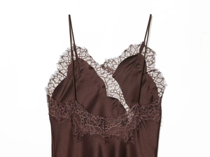 Detail of silk satin fabric with delicate brown eyelash lace trim on a camisole dress
