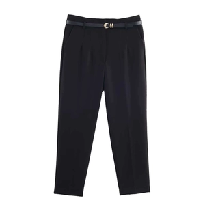 Women high waist black trousers with gold buckle belt in a minimalist formal office style