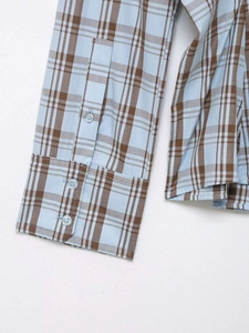 Detail der Manschetten am hellblau karierten Hemd mit drei transparenten Knöpfen