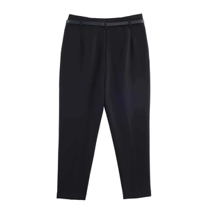 Detailed close-up of black high-waisted dress pants with matching belt and pleats