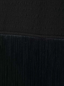 Dettaglio della trama del tessuto nero arricciato e delle frange sul vestito elegante