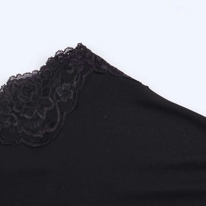 Close-up of intricate black floral lace trim and seam detail on a summer dress