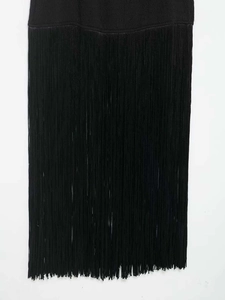 Dettaglio di un elegante abito nero senza maniche con nappe a frangia fitte e lunghe