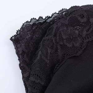 Detail of black lace dress showing intricate embroidery patterns and scalloped edges