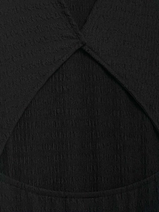 Dettaglio di un abito nero con trama in tessuto creponne e design a incrocio