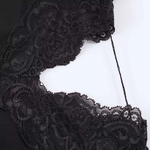 Detailed view of black floral lace stitching and scalloped edges on fashion dress