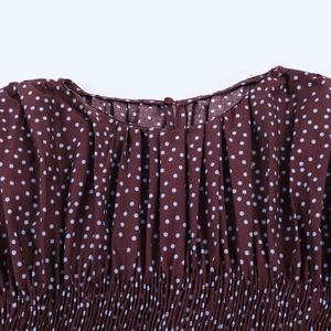 Detalle de la blusa marrón con lunares, diseño fruncido y cierre de botón en la espalda