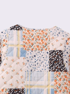 Close-up of quilted floral patchwork jacket with diverse vintage patterns and diamond stitching