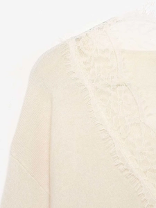 Détail du haut en tricot crème avec dentelle cil élégante sur le décolleté raffiné
