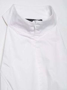 Détail de col montant avec fermeture éclair invisible et étiquette noire sur robe