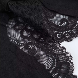 Detailed macro view of the intricate floral lace embroidery on the black summer dress