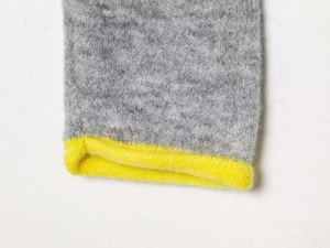 Close-up of dark grey knit fabric with a bright yellow ribbed edge detail for soft texture