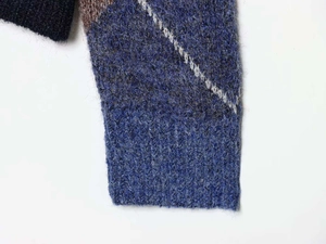 Detail of ribbed cuff and argyle pattern on fuzzy mohair blend knit sweater