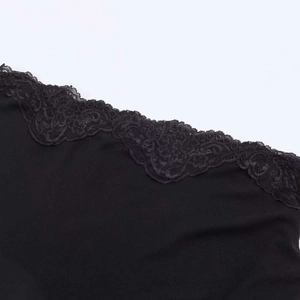 Close-up of black summer dress featuring delicate floral lace trim and knit texture