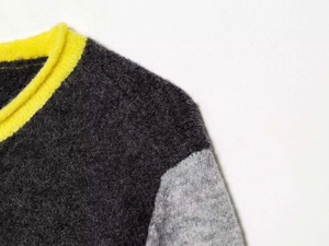 Detail of knit sweater with long-hair plush texture and yellow trim contrast