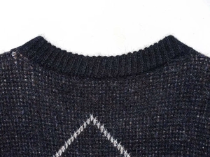 Detail of crew neck ribbing and white geometric diamond jacquard pattern on knit sweater