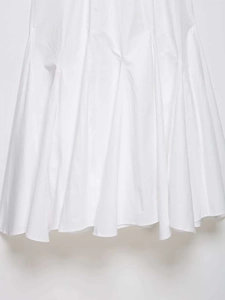 Détail macro de l'ourlet de la robe blanche avec coutures verticales et plis délicats