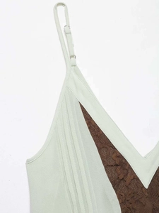 Detail of light green pleated fabric with brown lace trim and adjustable straps
