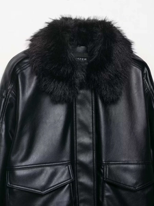 Detail einer schwarzen Kunstlederjacke mit dichtem Pelzkragen und großen Pattentaschen