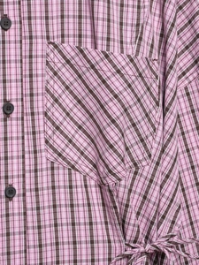 Detail of pink plaid shirt featuring brown buttons and adjustable side drawstring waist