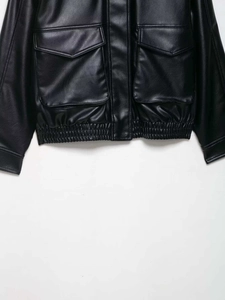 Detailansicht der schwarzen Kunstlederjacke mit großen Pattentaschen und Rippbündchen am Saum