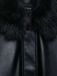 Details des schwarzen Pelzkragens und der Lederstruktur der Jacke von FEIR