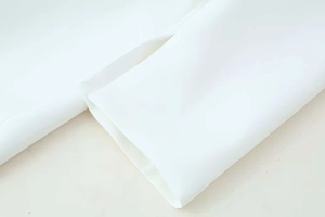 Close-up of clean white long-sleeved dress cuff with decorative button details