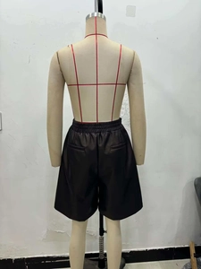 Vue détaillée du dos d'un short en simili cuir foncé avec taille élastique et poches