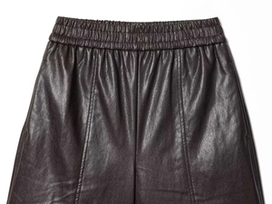 Détail de la taille élastique et des coutures sur un short en similicuir foncé