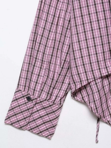 Close-up of pink plaid shirt sleeve with black button and side drawstring detail
