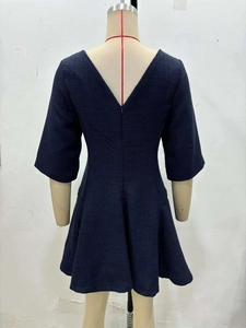 Detailed back view of a navy blue tweed dress featuring a deep V-neck and A-line silhouette