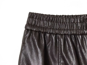 Détail de la taille haute élastique et de la texture grainée du short en similicuir marron foncé