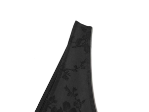 Close-up detail of black jacquard fabric with floral dark pattern on minimalist summer dress