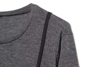 Close-up of dark grey knit top with round neck and black contrast shoulder tape