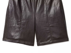 Gros plan détaillé sur la texture du similicuir et les surpiqûres verticales du short