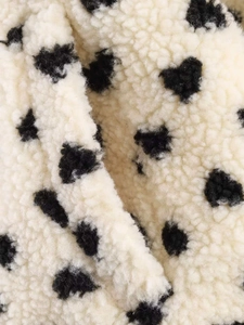 Gros plan sur la veste en polaire blanche douce avec motif à pois en forme de cœurs