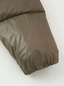 Close-up of olive green puffer jacket sleeve with elastic cuff and quilted texture