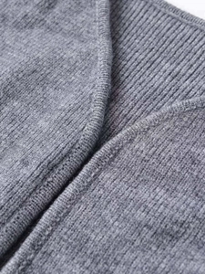 Nahaufnahme der hellgrauen Strickjacke mit feiner Jersey- und Rippstrick-Struktur