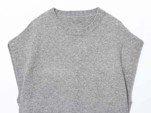 Detailed close-up of light gray knitted crew neck vest with fine stitching texture