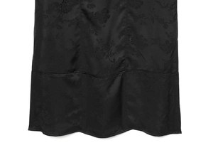 Close-up of black jacquard satin dress with floral patterns and wavy curved hemline