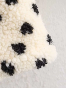 Vue détaillée de la veste en fausse fourrure crème douce avec motif à pois noirs classique
