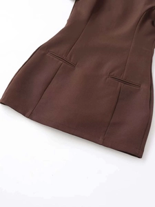 Detail of caramel pleated dress featuring symmetrical welt pockets and smooth texture