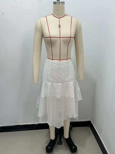 Detail view of white chiffon skirt featuring black polka dots and irregular ruffle hem
