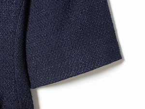 Macro view of navy blue tweed fabric texture showing detailed weave and quality stitching