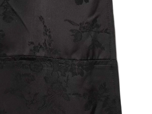 Detailed macro view of black floral jacquard fabric texture and neat stitching on dress