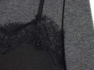 Detailed close-up of delicate black eyelash lace trim on a velvet camisole dress