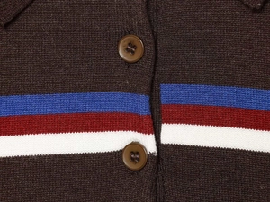 Detail of dark brown knit sweater with contrasting stripes and resin button closure