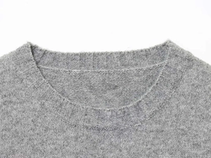 Close-up of the ribbed crewneck and fine light gray knit texture on this slim sleeveless top